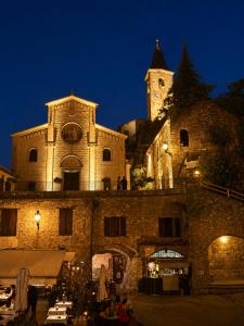 a large stone building with a clock tower at night at La Rocca Sospesa in Apricale +19 photos