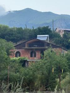 a brick house on a hill with mountains in the background at Aygut Garden in Aygut