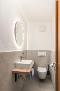a bathroom with a sink and a toilet and a mirror at Residence Diana Apartment 303 in Terento +21 photos