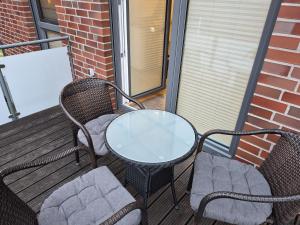 a patio with two chairs and a table on a balcony at Tillmanns Ankerplatz in Norden