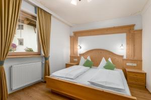 a bedroom with a large bed and a window at Residence Diana Apartment 303 in Terento