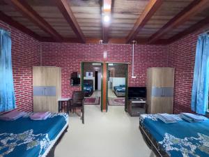 a room with two beds and a brick wall at Georium Dunia in Prambanan