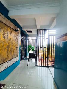 a hallway with a room with blue walls and windows at Skyline Guest House in Kinshasa