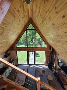 an attic view of a log cabin with a large window at Cabana ONYX Baile Olanesti in Băile Olăneşti