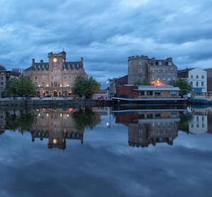 a city with buildings and a river at night at Malmaison Edinburgh in Edinburgh