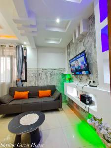 a living room with a couch and a tv at Skyline Guest House in Kinshasa +5 photos