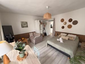 a living room with a bed and a table at Grand Studio Centre Fontainebleau INSEAD - Cocon Deluxe in Fontainebleau