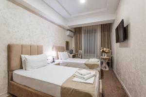 a hotel room with two beds and a television at Hotel Dream Land Tashkent in Tashkent +12 photos