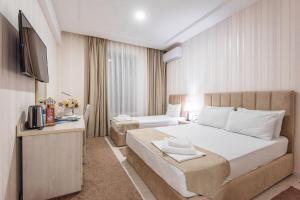 a hotel room with a bed and a television at Hotel Dream Land Tashkent in Tashkent