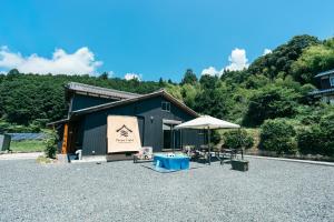 a building with an umbrella and a table and chairs at 1日1組限定 一棟貸し Japanese Traditional House Three Field Tamba-Sasayama in Sasayama