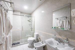 a bathroom with a sink and a toilet and a shower at Hotel Dream Land Tashkent in Tashkent