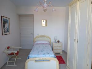a small bedroom with a bed and a chandelier at Casa Evelina in Villanovotulo