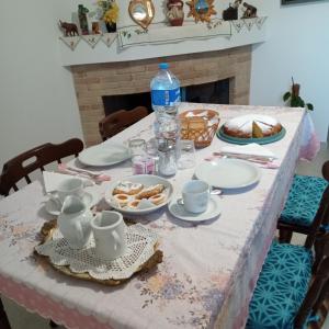 a table with plates and cups and a table with food at Casa Evelina in Villanovotulo