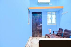 a blue room with a table and a chair at Hotel O Elegant Stay CDA in Cuttack