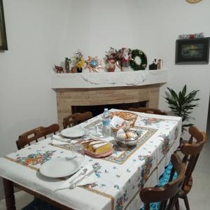a dining room table with a table cloth and a fireplace at Casa Evelina in Villanovotulo