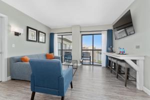 a living room with a couch and a table and a tv at Lake View Top Floor 2 Bed 2 Bath Condo with Balcony in Orlando +37 photos