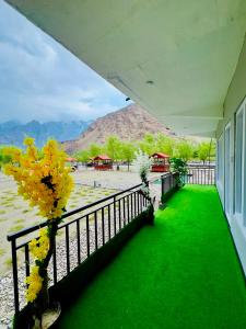 a balcony with green grass and a fence at Saleem Resort in Skardu +32 photos