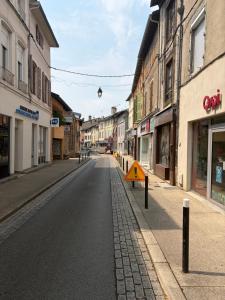 an empty street in a town with buildings at Appartement centre-ville Montluel in Montluel