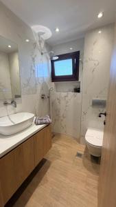 a bathroom with a sink and a toilet at Sabbia Suites in Nea Vrasna +32 photos