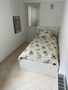 a small bedroom with a bed with a flowery comforter at Le Cepyo in Saint-Quentin