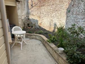 a table and a chair sitting on a patio at Le Cepyo in Saint-Quentin