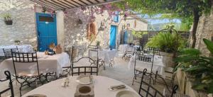 a restaurant with white tables and chairs and flowers at Maison Carles BnB in La Colle-sur-Loup