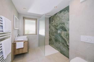 a bathroom with a shower and a large painting on the wall at Haus Martinus in Mayrhofen