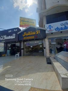a store front of a shopping center with signs at فندق نوارة المنسك in Abha