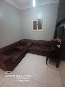 a brown couch in a living room with a desk at فندق نوارة المنسك in Abha
