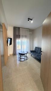 a living room with a couch and a table at Sabbia Suites in Nea Vrasna