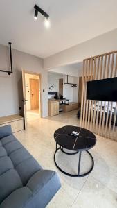 a living room with a couch and a table at Sabbia Suites in Nea Vrasna