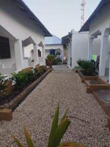 a courtyard of a house with a gravel driveway at Fun Haribo B&B Apartment in Uroa