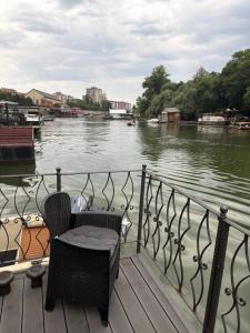 a chair sitting on a deck next to a river at Vasilisa Luxury River House in Pančevo