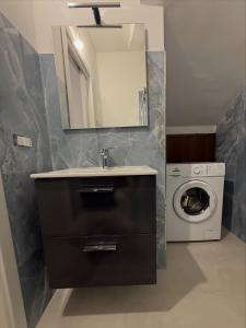 a bathroom with a sink and a washing machine at Angelo in Futani