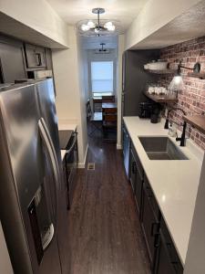 Eine Küche mit Edelstahlkühlschrank und Holzböden in der Unterkunft Super Nice! Unit #3 in Lincoln