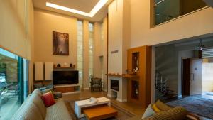 a living room with a couch and a tv at Villa Diva in Kemer