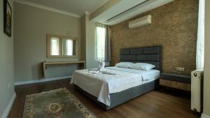 a bedroom with a large bed and a brick wall at Villa Diva in Kemer +66 photos