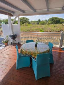 a patio with a table and chairs on a deck at BungalowFlo - Maison de vacances avec Spa in Petit-Canal +5 photos