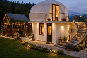a large white house with lights in the yard at Akho Panorama in Batumi