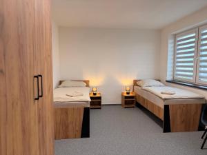 a room with two beds and a window at Kolík Apartmány in Bohumín
