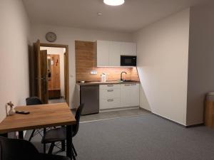 a kitchen with a table and a sink and a counter at Kolík Apartmány in Bohumín