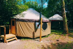a yurt with a wooden staircase in front of it at Yurtcamp Devon in Heathfield