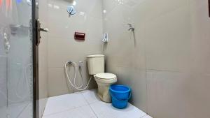 a bathroom with a shower and a toilet and a blue bucket at Pildacil in Garut +21 photos