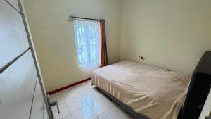 a small bedroom with a bed and a window at Pildacil in Garut