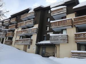 an apartment building with snow in front of it at Duplex la Plagne Montalbert in Aime-La Plagne