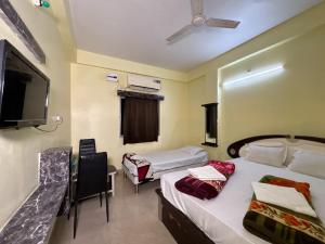 a hotel room with two beds and a tv at Hotel Radiation Deoghar in Deoghar +40 photos