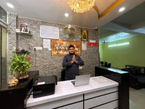 a man standing behind a counter in an office at Hotel Radiation Deoghar in Deoghar