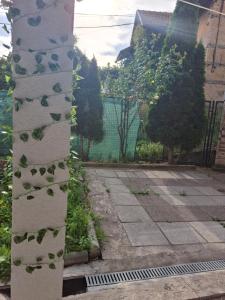 a wall with leaves on it next to a sidewalk at Apartman Mickey in Sarajevo