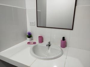 a bathroom sink with a mirror and a pink soap dispenser at BACHÍG Hospedaje in Moyobamba +60 photos