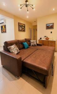 a large brown couch in a living room at Nandos Places in Puerto Barrios